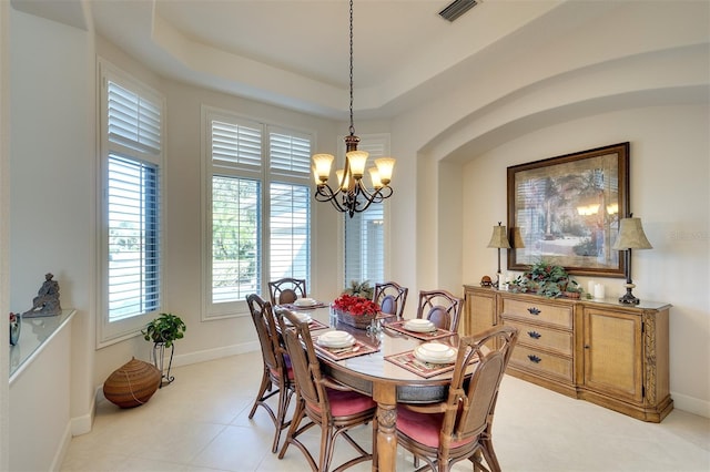 dining room featuring a raised ceiling and a notable chandelier