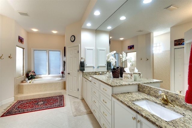 bathroom with tile patterned flooring, vanity, and a tub