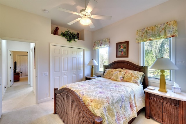 carpeted bedroom with ceiling fan and a closet