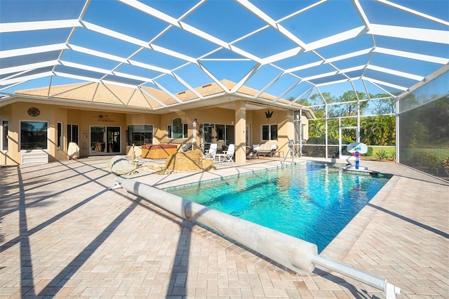 view of swimming pool featuring a lanai, ceiling fan, and a patio