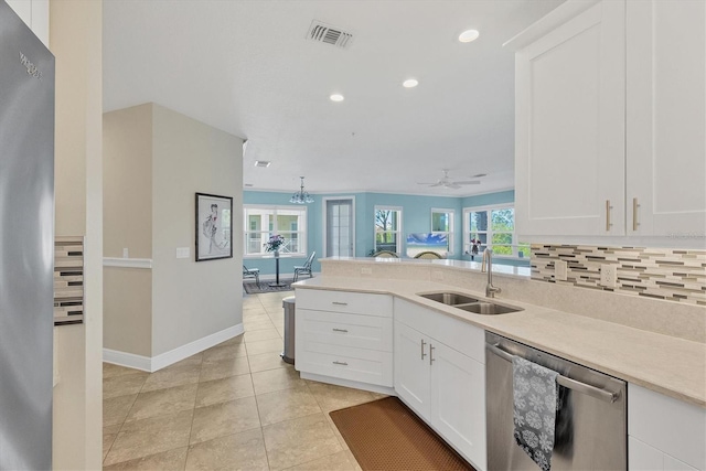 kitchen featuring decorative backsplash, white cabinetry, stainless steel dishwasher, and sink