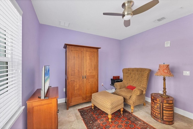 living area with ceiling fan and light tile patterned flooring