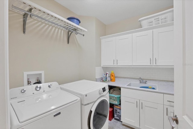 laundry room with washer and clothes dryer, cabinets, and sink