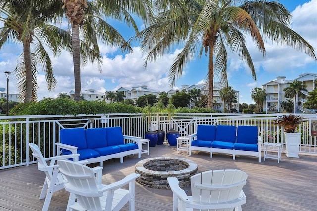 deck featuring an outdoor living space with a fire pit