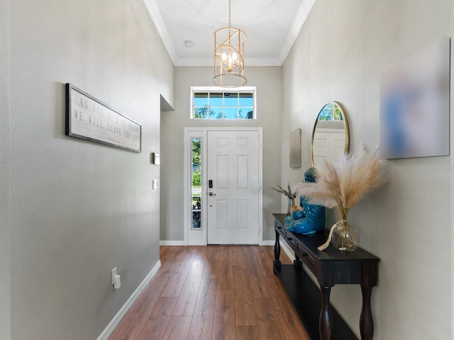 entryway featuring ornamental molding, dark wood-type flooring, a towering ceiling, and a chandelier