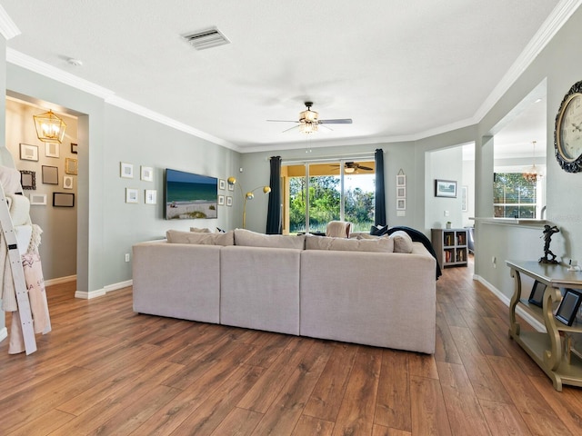 living room featuring crown molding, hardwood / wood-style floors, and ceiling fan with notable chandelier