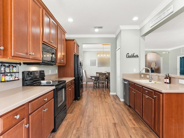 kitchen featuring crown molding, sink, black appliances, and light hardwood / wood-style floors