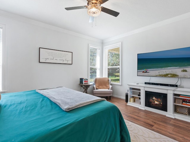 bedroom featuring hardwood / wood-style floors, ceiling fan, and crown molding