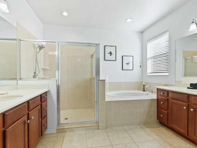 bathroom featuring plus walk in shower, vanity, and tile patterned flooring