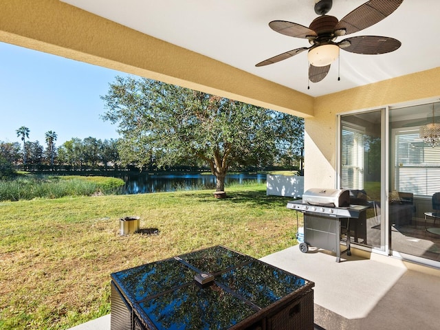 view of yard with ceiling fan and a water view