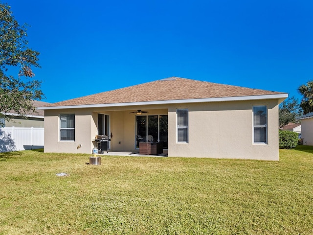 back of property featuring a yard and ceiling fan