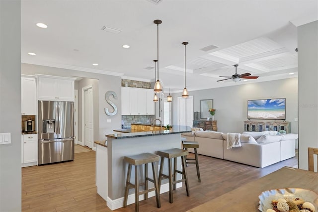 kitchen featuring light hardwood / wood-style floors, white cabinetry, stainless steel fridge with ice dispenser, and pendant lighting