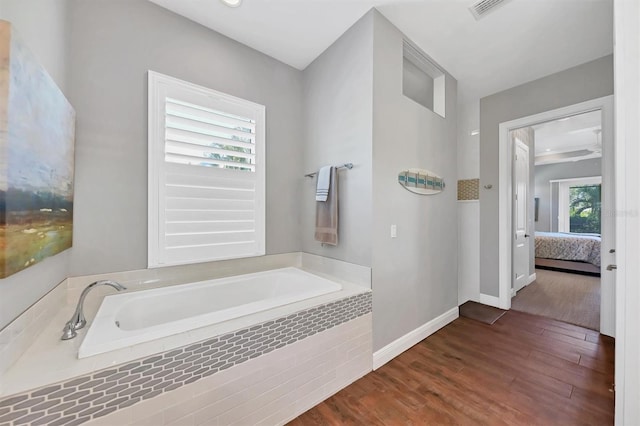 bathroom featuring wood-type flooring and tiled tub