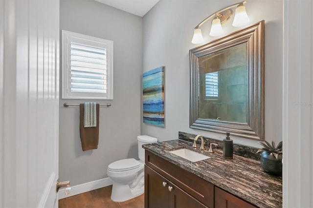 bathroom featuring vanity, wood-type flooring, and toilet