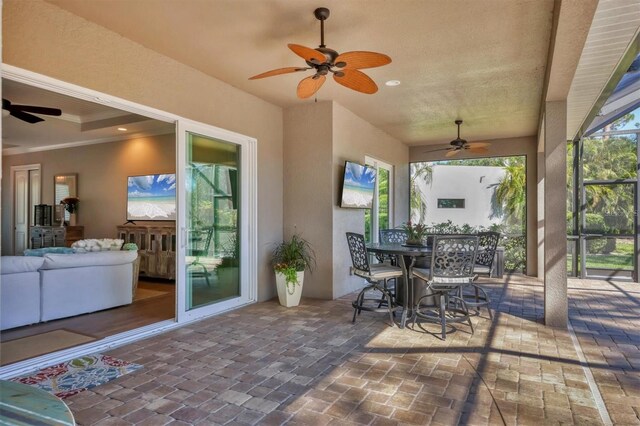 view of patio / terrace featuring glass enclosure and ceiling fan