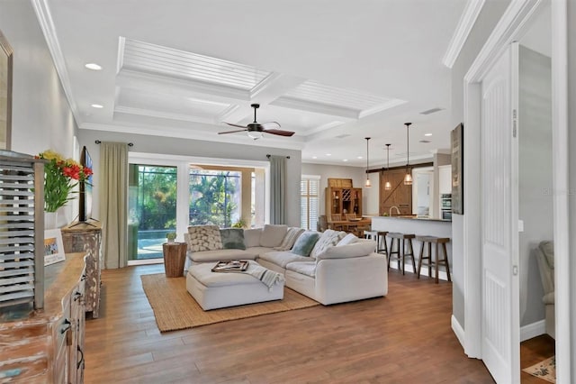 living room with crown molding, wood-type flooring, and coffered ceiling