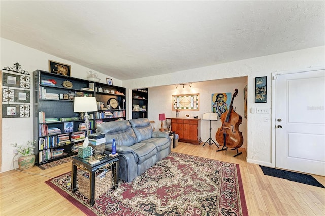 living room with a textured ceiling and light hardwood / wood-style flooring