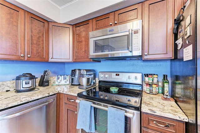 kitchen featuring light stone counters and stainless steel appliances