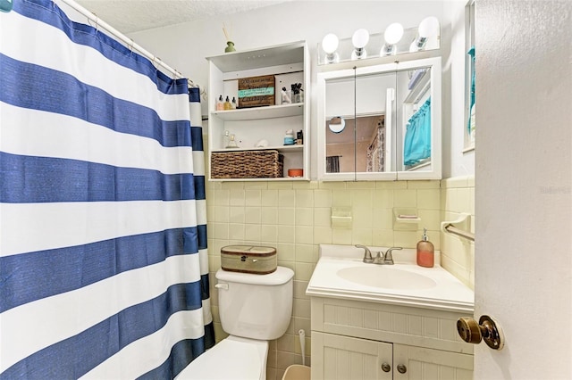 bathroom featuring a shower with curtain, a textured ceiling, toilet, vanity, and tile walls