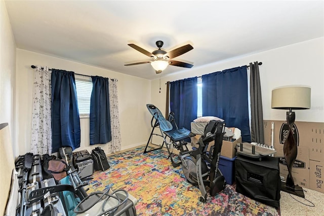 exercise area featuring ceiling fan and carpet floors