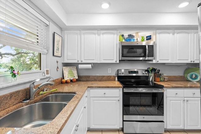 kitchen featuring white cabinets, light stone counters, sink, and appliances with stainless steel finishes