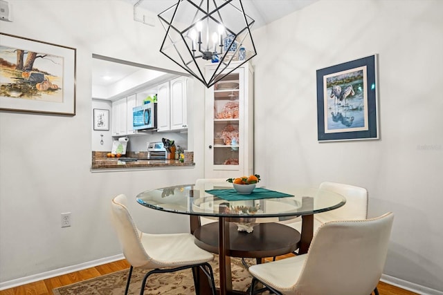 dining area featuring hardwood / wood-style flooring and a notable chandelier