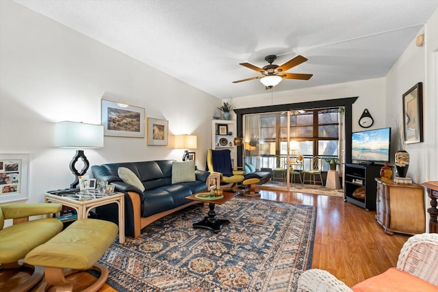 living room with ceiling fan, light hardwood / wood-style flooring, and a textured ceiling