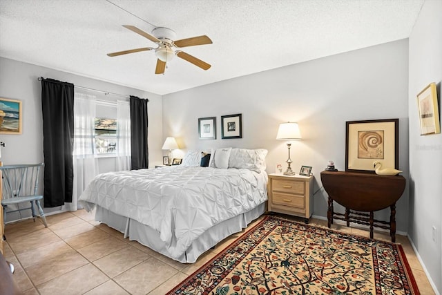 bedroom featuring ceiling fan, light tile patterned flooring, and a textured ceiling