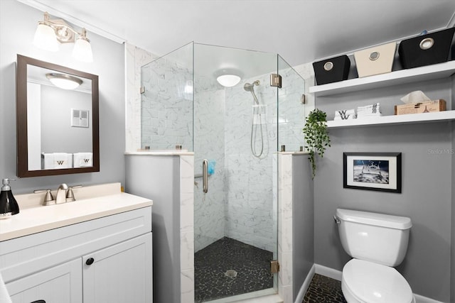 bathroom featuring vanity, toilet, and a shower with door