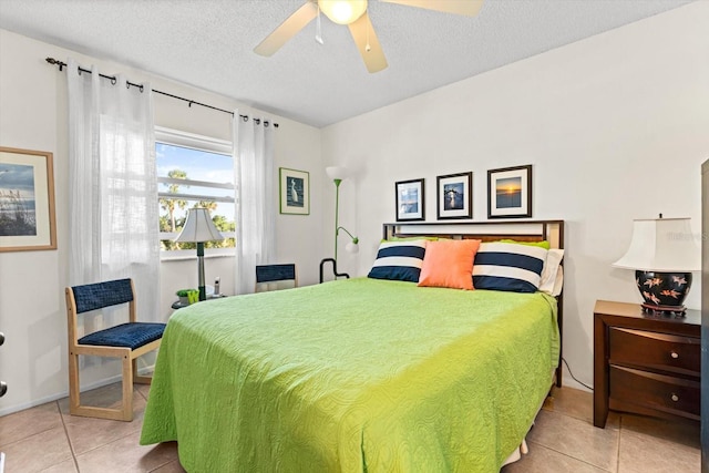 tiled bedroom with ceiling fan and a textured ceiling