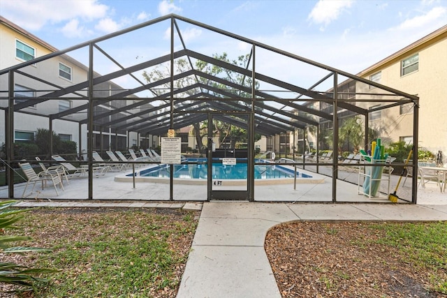 view of pool with glass enclosure and a patio area