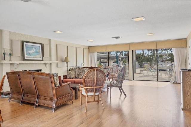 interior space featuring light wood-type flooring, a large fireplace, and plenty of natural light