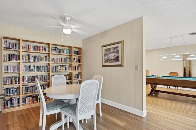 dining room with ceiling fan, wood-type flooring, and a textured ceiling