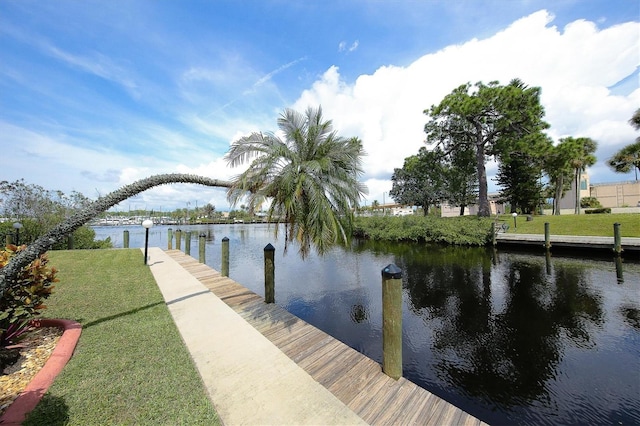 dock area with a lawn and a water view