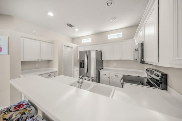 kitchen with kitchen peninsula, stainless steel appliances, white cabinetry, and sink