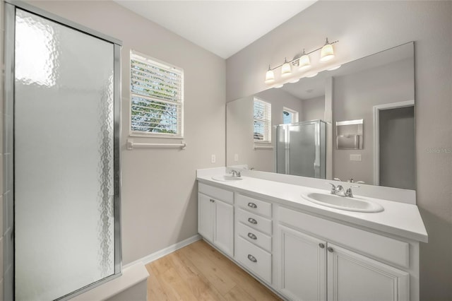 bathroom with hardwood / wood-style flooring, vanity, a healthy amount of sunlight, and walk in shower