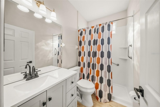 bathroom with hardwood / wood-style floors, vanity, toilet, and walk in shower