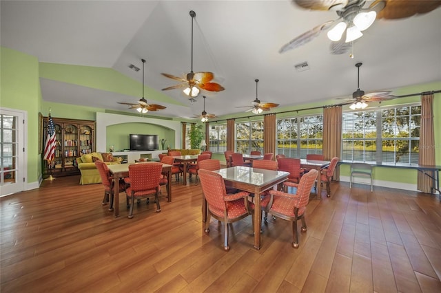 dining room featuring hardwood / wood-style floors, a healthy amount of sunlight, and vaulted ceiling