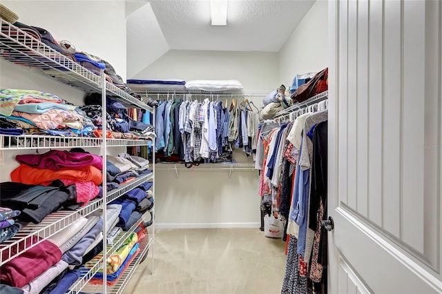 walk in closet featuring light colored carpet