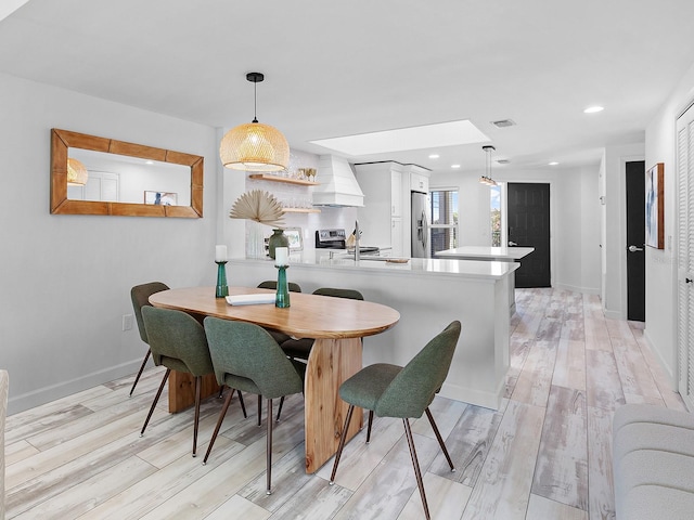 dining space featuring light hardwood / wood-style floors and sink