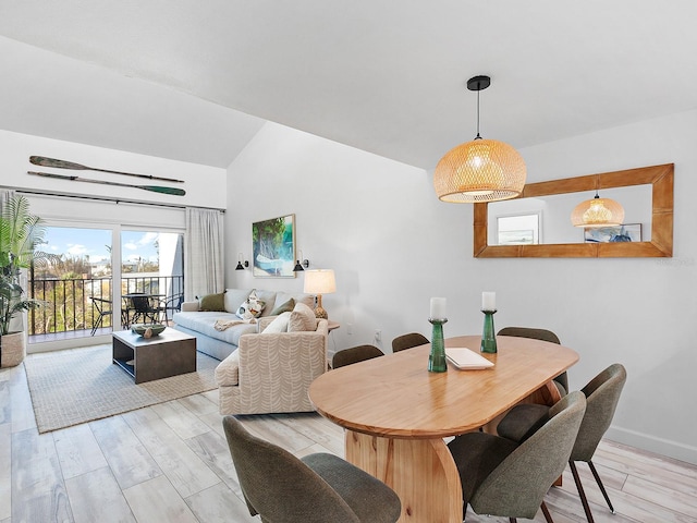 dining space with light hardwood / wood-style flooring and lofted ceiling