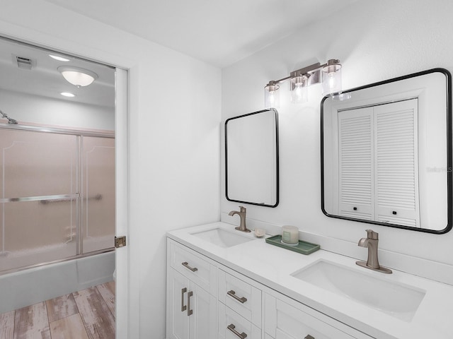 bathroom featuring combined bath / shower with glass door, vanity, and hardwood / wood-style flooring