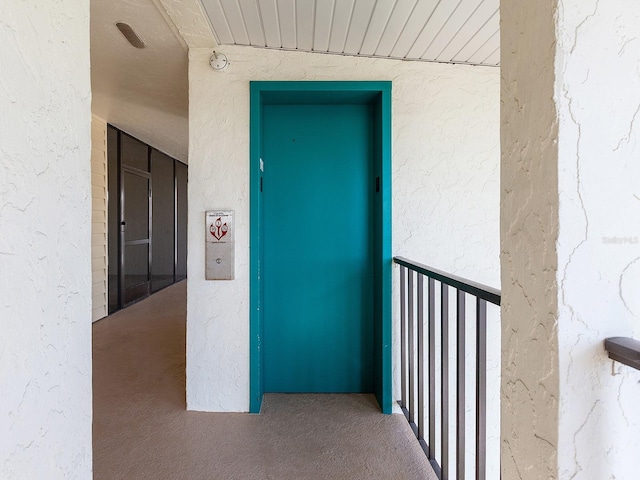 doorway to property featuring a balcony and elevator