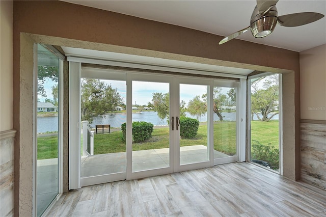 entryway with a healthy amount of sunlight, a water view, and light hardwood / wood-style floors