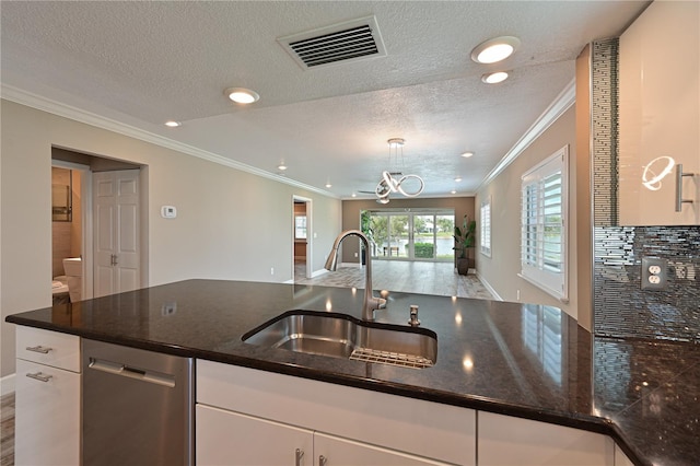 kitchen featuring white cabinetry, sink, dishwasher, crown molding, and a textured ceiling