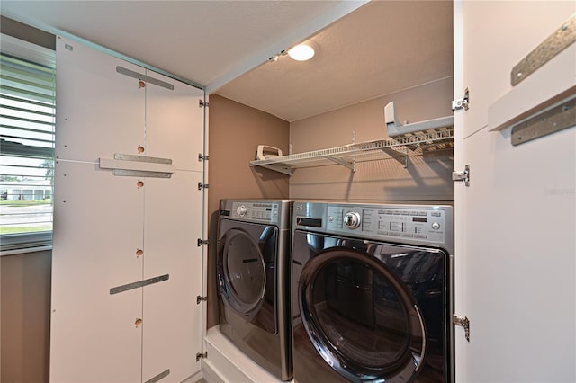 washroom with washing machine and clothes dryer and a textured ceiling