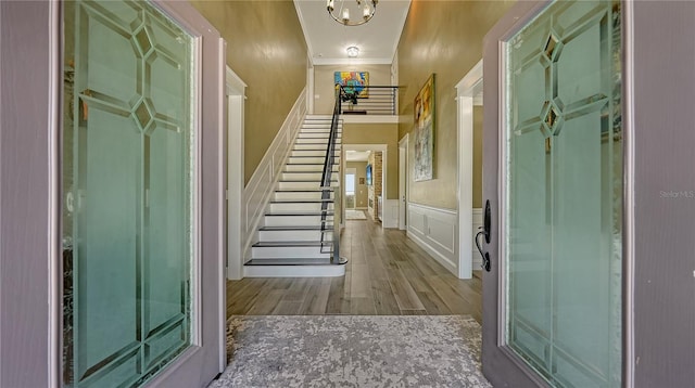 foyer entrance with hardwood / wood-style flooring and ornamental molding