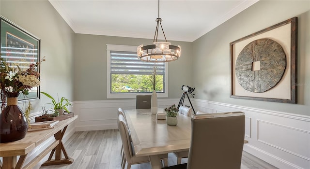 dining room featuring ornamental molding, light wood-type flooring, and a notable chandelier