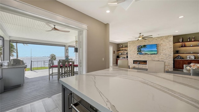 interior space with a fireplace, a water view, and light wood-type flooring