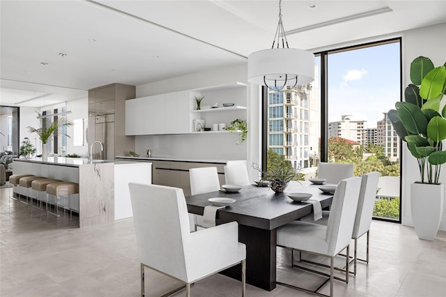 509 Golden Gate Pt Unit 3, Sarasota, FL 34236 - dining room featuring a wall of windows, healthy amount of natural light, a tray ceiling, and a chandelier